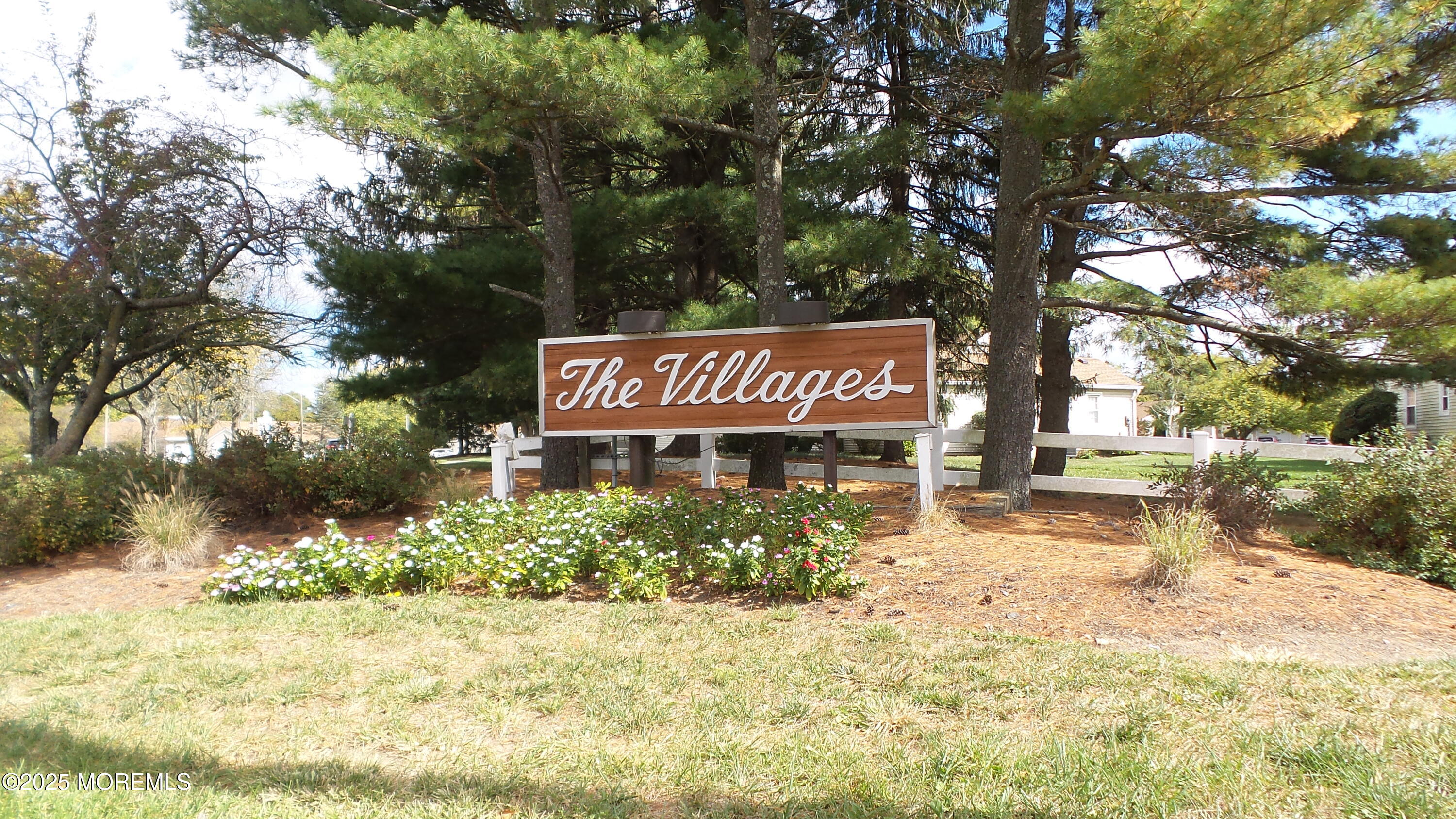 a sign that is sitting in front of a tree