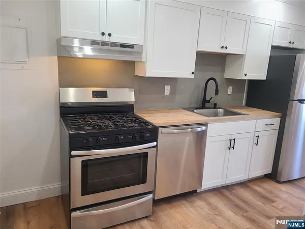 a kitchen with a stove sink and cabinets