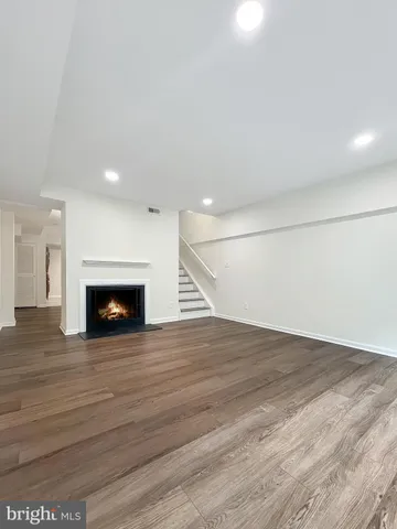 a view of empty room with wooden floor and fireplace