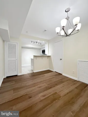 a view of a room with wooden floor and ceiling fan