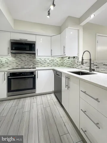a kitchen with stainless steel appliances granite countertop a stove microwave and sink