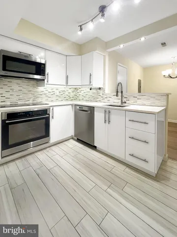 a kitchen with granite countertop cabinets stainless steel appliances and a counter space
