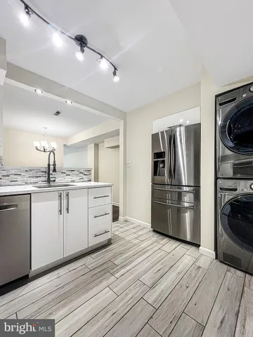 a kitchen with a refrigerator stove and white cabinets