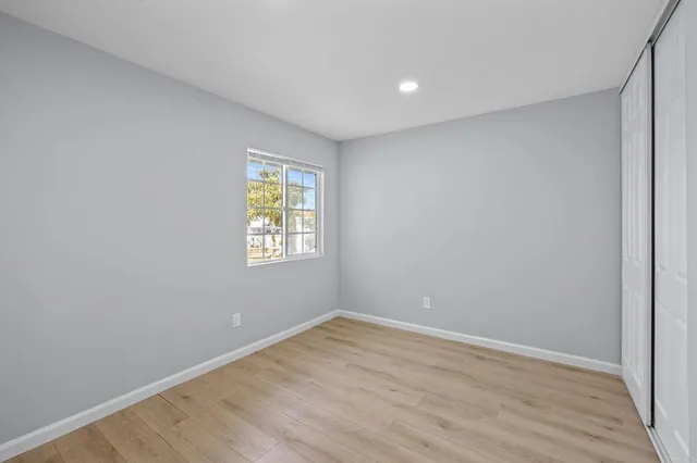 a view of an empty room with wooden floor
