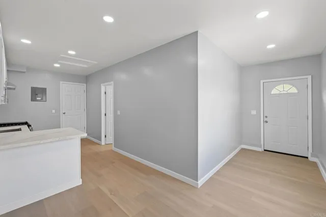 a kitchen with a refrigerator and white cabinets