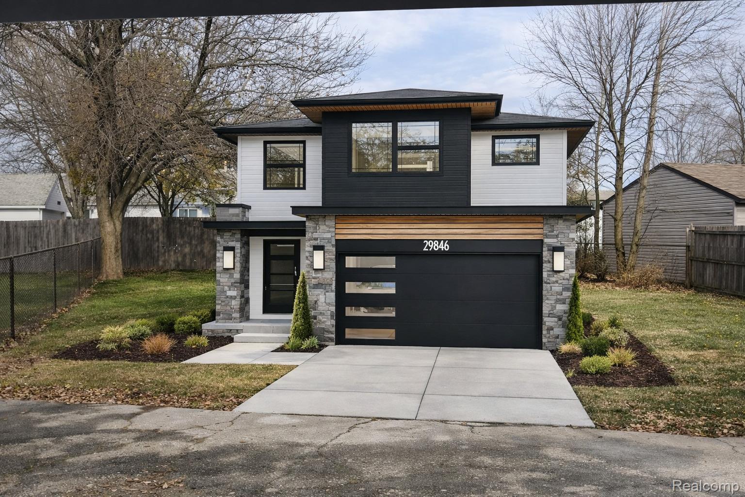 16641 Stephens Road Eastpointe, MI 48021 - Photo 1 of 3 Contemporary two-story residence featuring a striking black and white exterior with wood-finish paneling accents