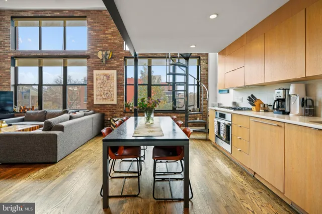 a kitchen with stainless steel appliances granite countertop a table chairs and a refrigerator