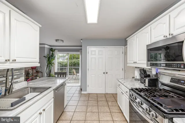 a kitchen with a sink a stove and a microwave
