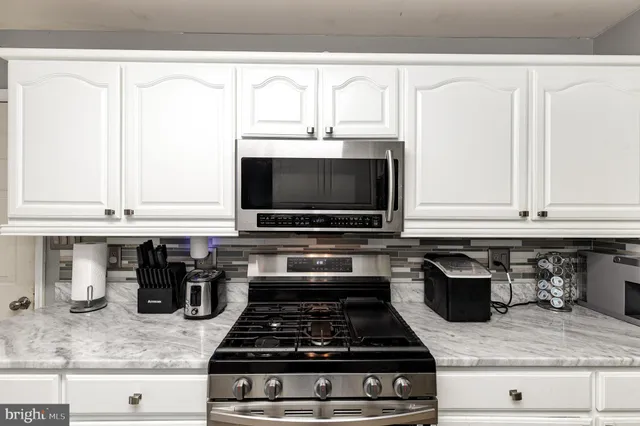 a kitchen with granite countertop a stove and a sink