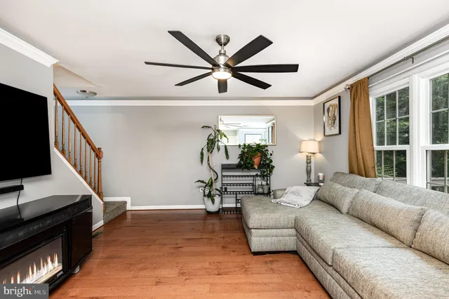 a living room with furniture and a flat screen tv with wooden floor