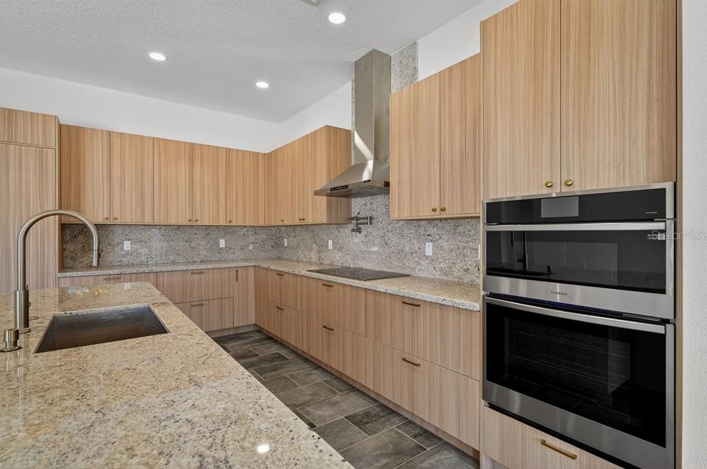 7 Crandon Court Palm Coast, FL 32137 - Photo 13 of 72 a kitchen with stainless steel appliances granite countertop a sink a stove and a microwave