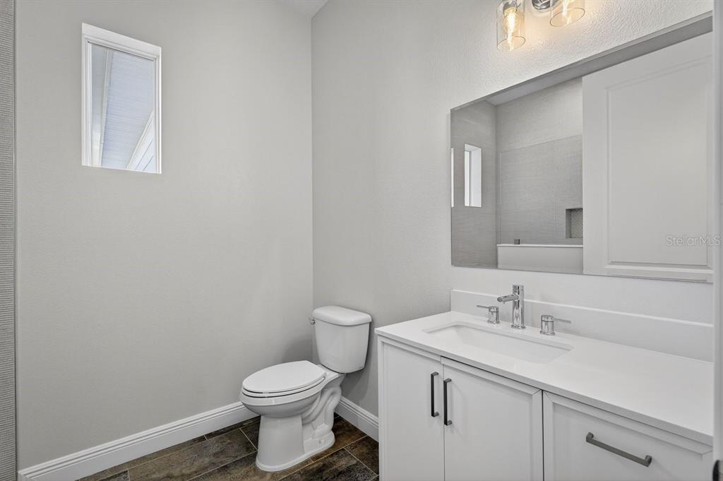 7 Crandon Court Palm Coast, FL 32137 - Photo 39 of 72 a bathroom with a sink a toilet and a mirror