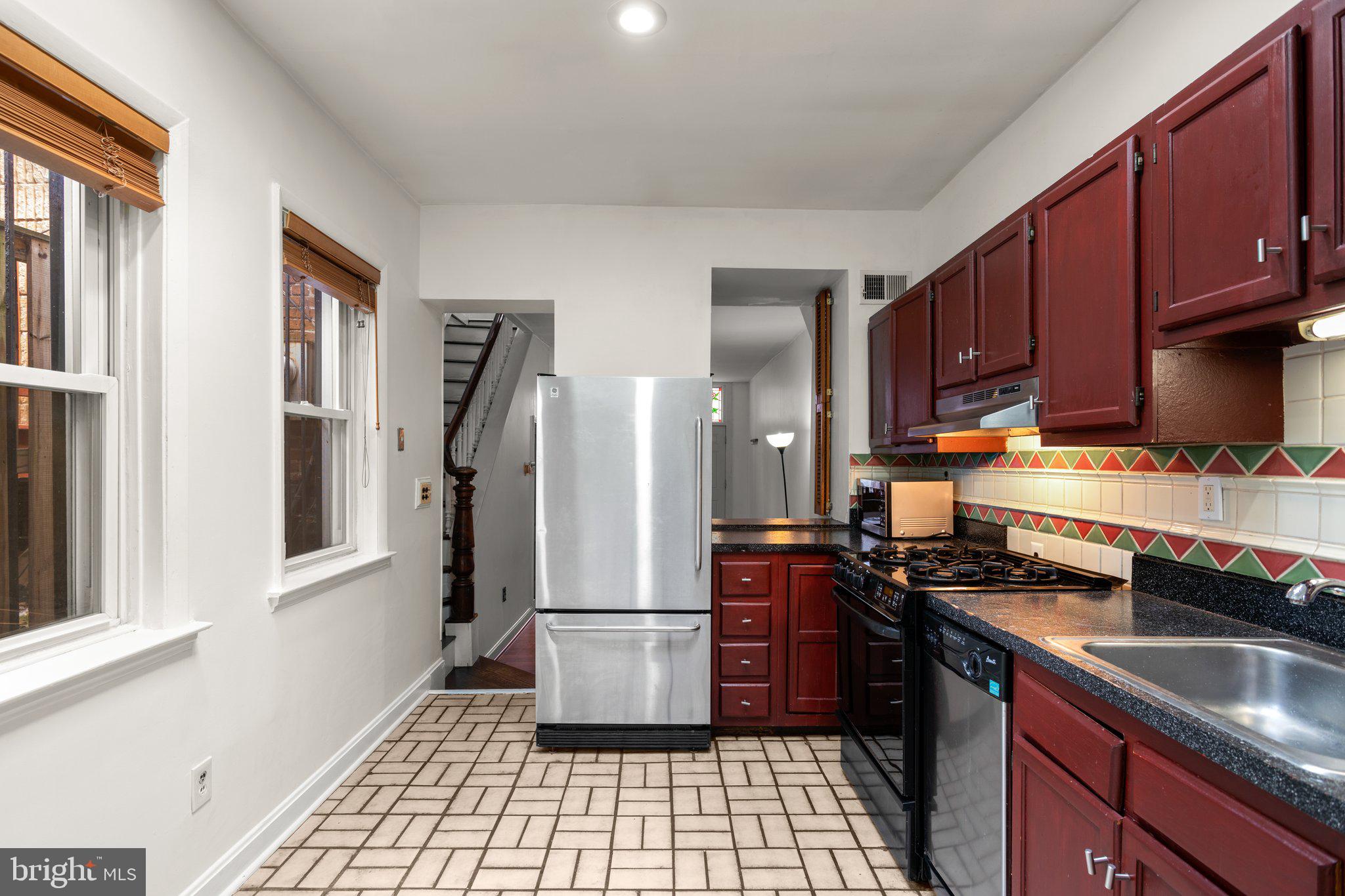 106 Scott Street Baltimore, MD 21201 - Photo 13 of 40 a kitchen with stainless steel appliances granite countertop a stove refrigerator and cabinets