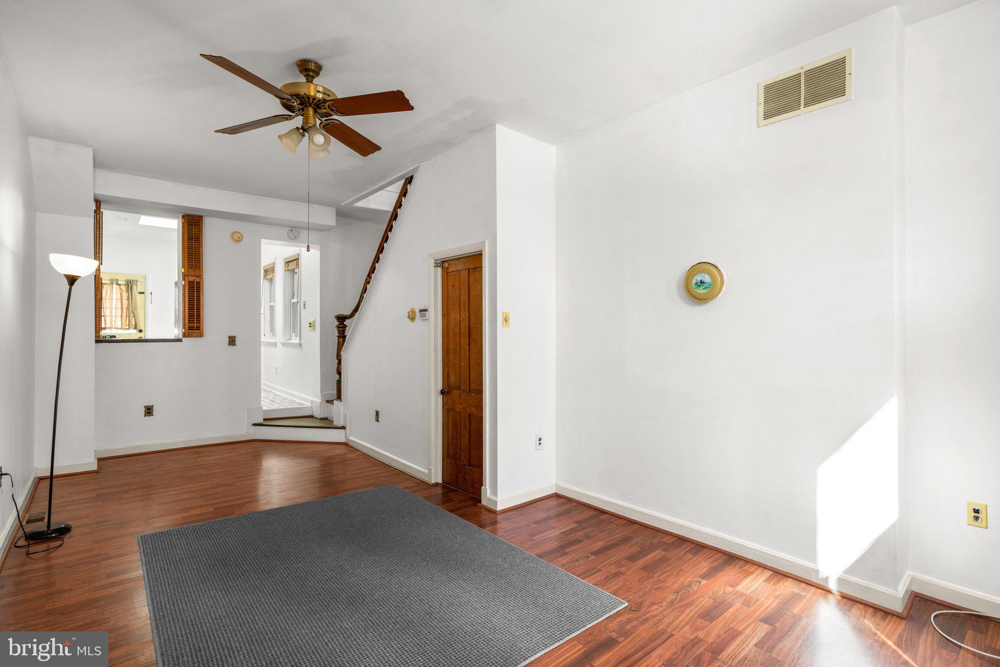 106 Scott Street Baltimore, MD 21201 - Photo 6 of 40 a view of a livingroom with wooden floor and a ceiling fan