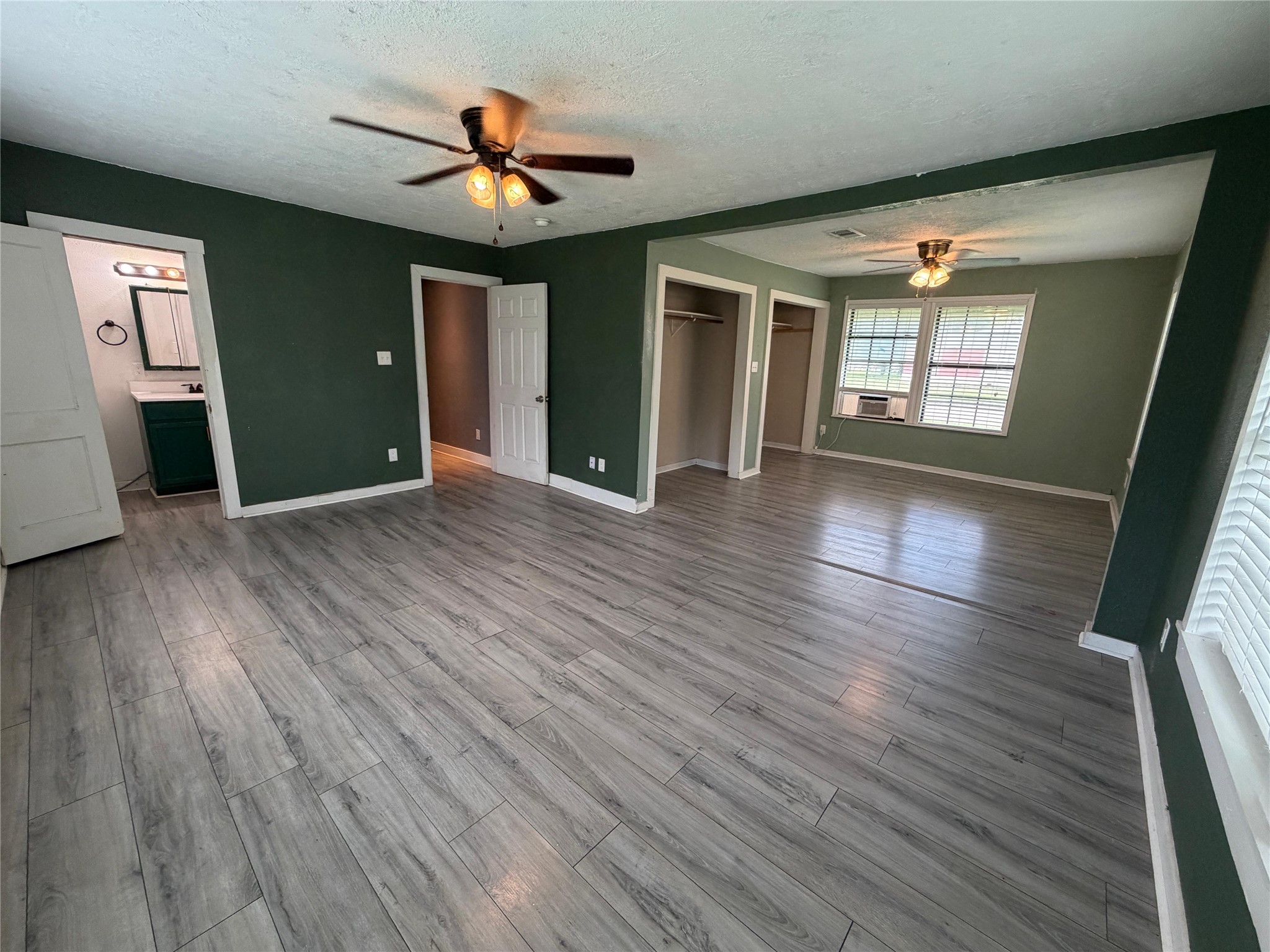 1401 East 29th Street Bryan, TX 77802 - Photo 3 of 13 A spacious room with two ceiling fans and durable flooring, offering ample space and natural light.