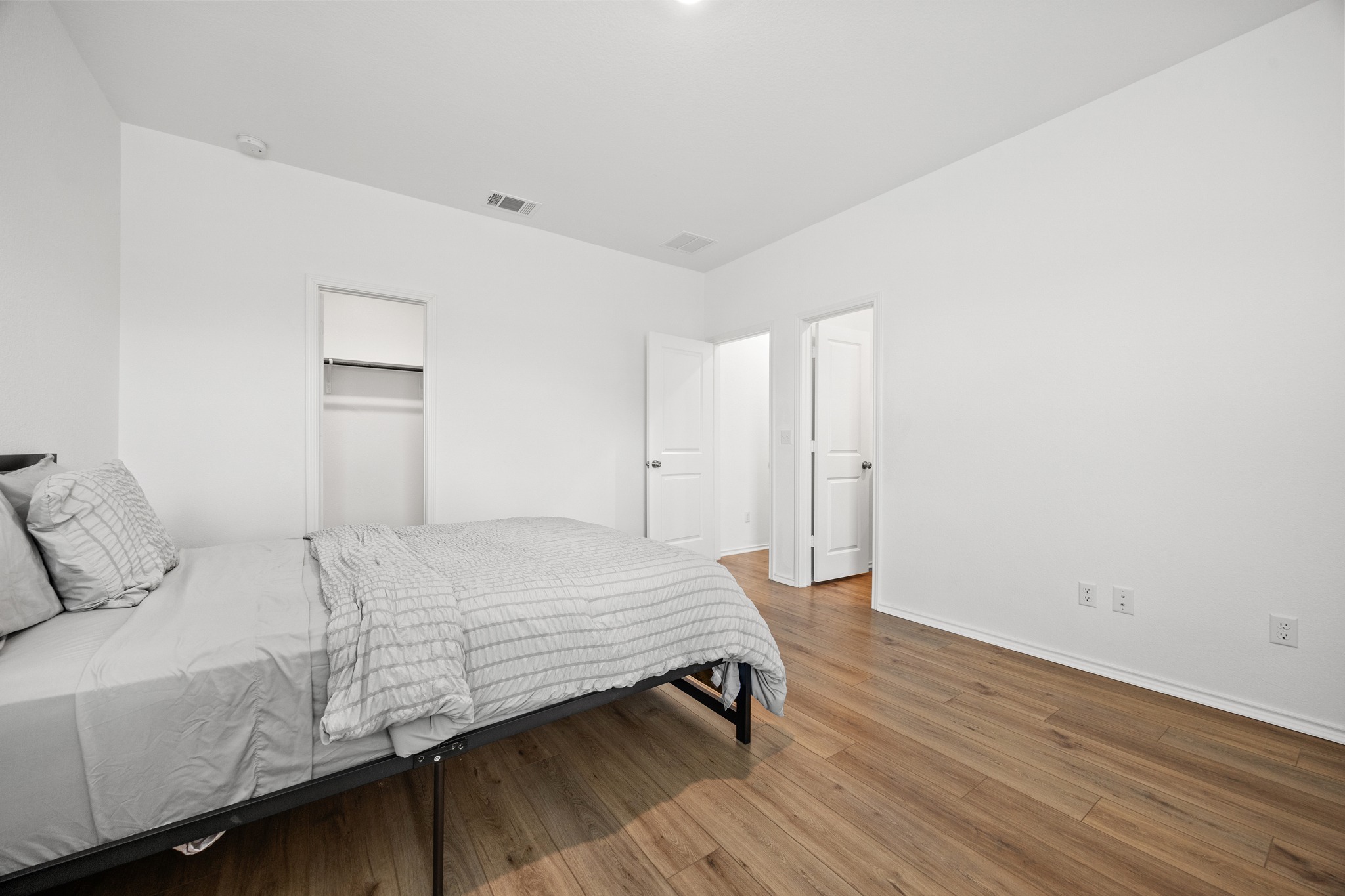 14121 Berning Road Manor, TX 78653 - Photo 10 of 27 Hardwood-style flooring and a simple closet define this peaceful sleeping space.