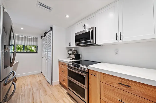 a kitchen with stainless steel appliances a stove microwave and a refrigerator