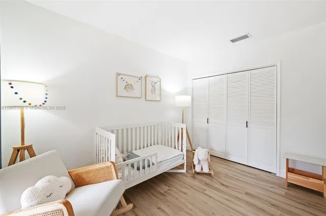 a view of a bedroom with furniture and wooden floor