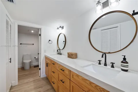 a bathroom with a sink mirror vanity and toilet