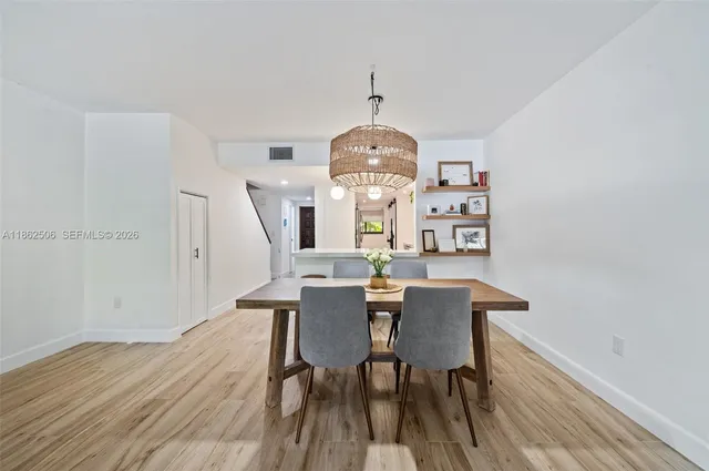 a view of a dining room with furniture a chandelier and wooden floor