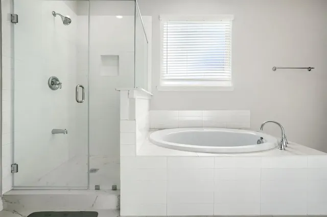 a bathroom with a white bath tub sitting next to a window
