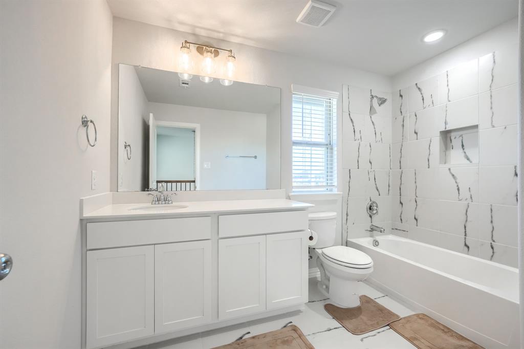 1309 Buttercup Road Prosper, TX 75078 - Photo 31 of 36 a spacious bathroom with a double vanity sink toilet mirror and bathtub