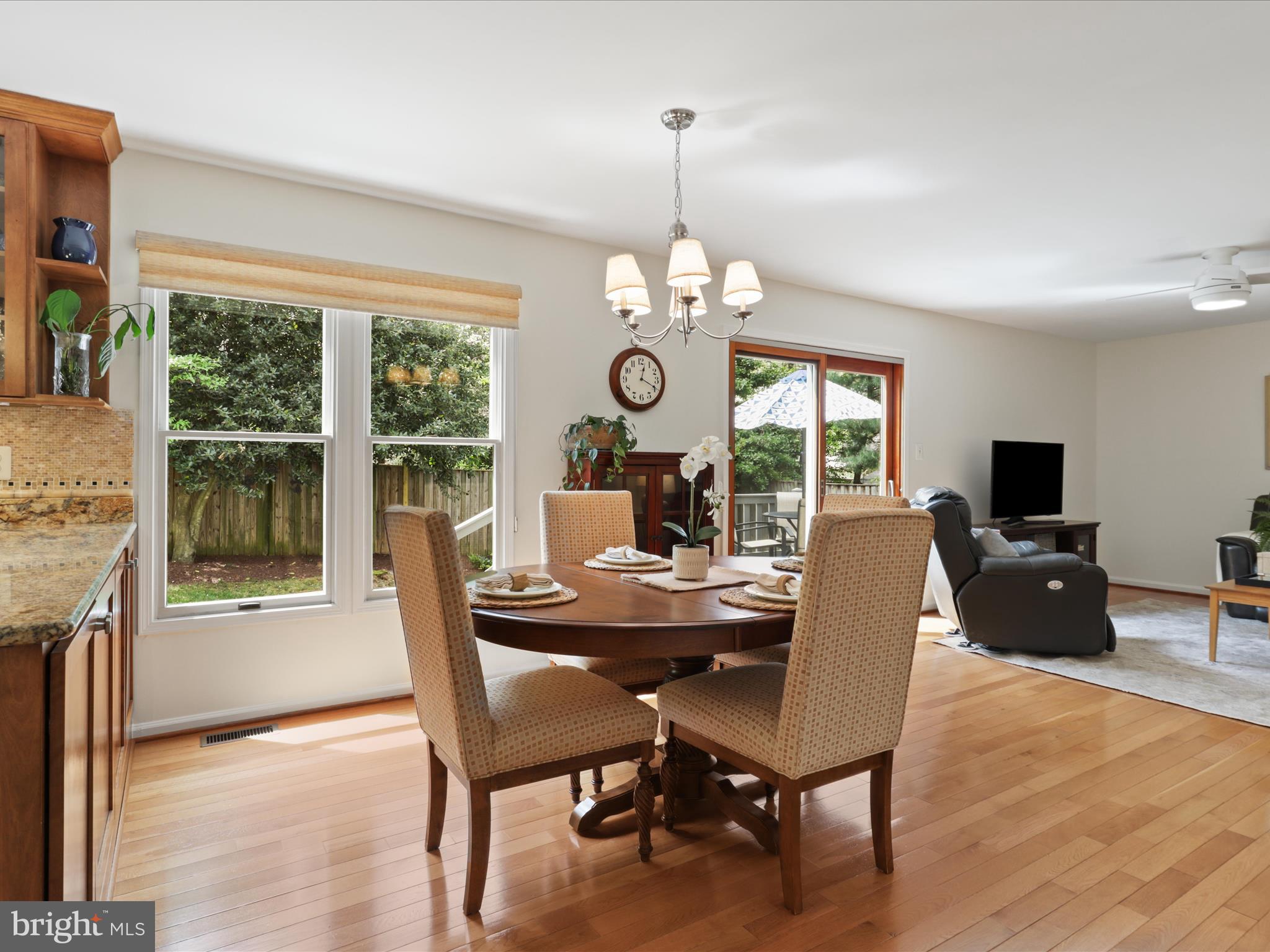 12021 Heather Down Drive Herndon, VA 20170 - Photo 11 of 47 a dining room with wooden floor a chandelier a wooden table and chairs