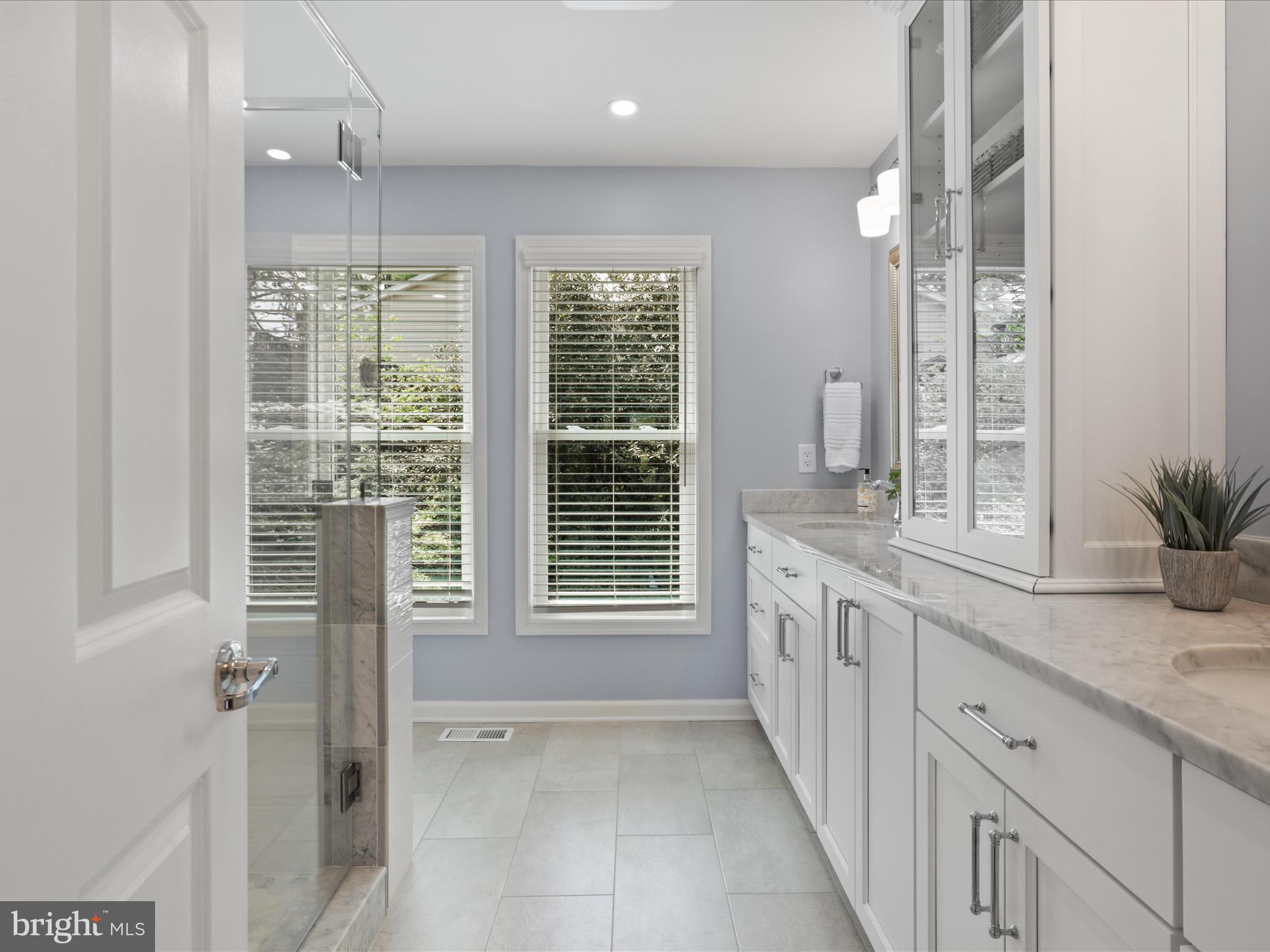 12021 Heather Down Drive Herndon, VA 20170 - Photo 26 of 47 a bathroom with a granite countertop sink a large mirror a bathtub and next to a window
