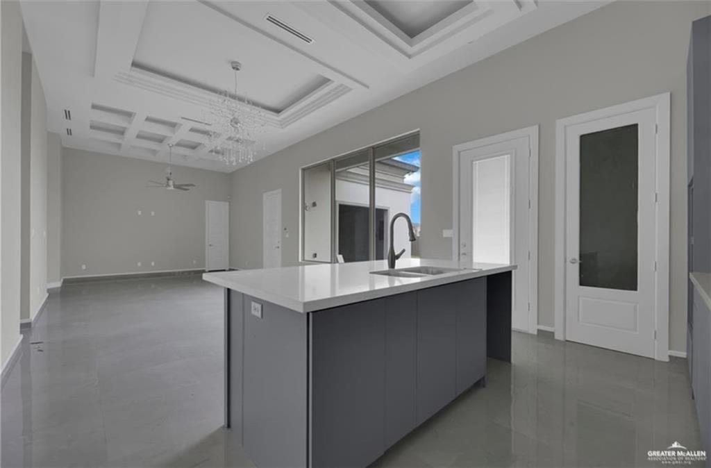 2516 Viola Street Mission, TX 78574 - Photo 3 of 17 Kitchen with coffered ceiling, an island with sink, modern cabinets, a chandelier, and pendant lighting