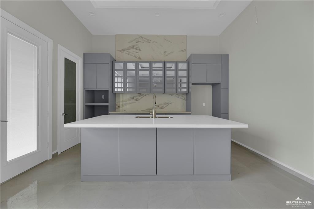 2516 Viola Street Mission, TX 78574 - Photo 7 of 17 Kitchen with gray cabinets, modern cabinets, a kitchen island with sink, and light stone countertops