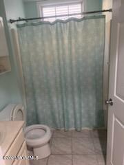 a bathroom with a toilet and a shower curtain