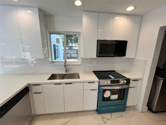 a kitchen with a sink stove and microwave