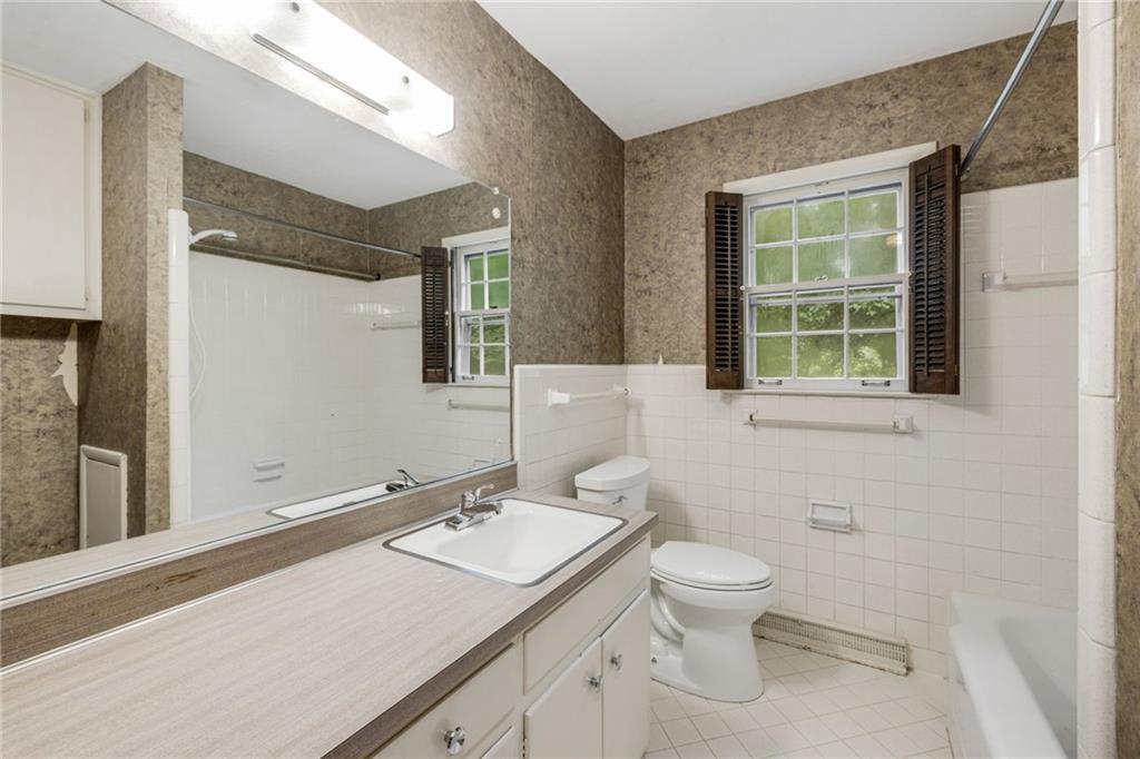 1911 Alderbrook Road Northeast Atlanta, GA 30345 - Photo 19 of 33 a bathroom with a granite countertop sink toilet and mirror