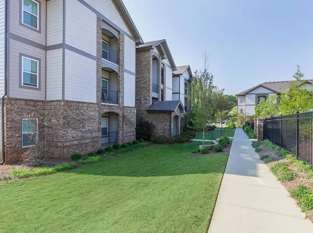 a view of a brick house with a yard and plants