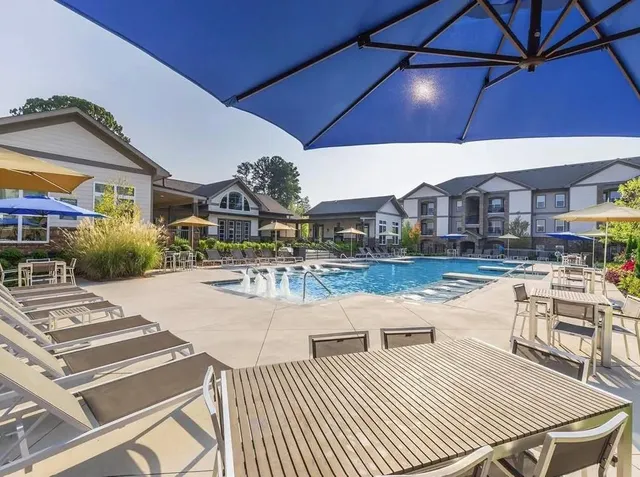 a view of a patio with dining table and chairs under an umbrella