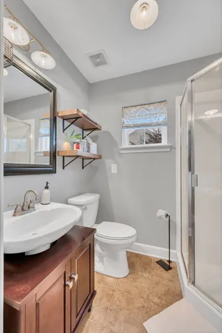 a bathroom with a sink a toilet and mirror
