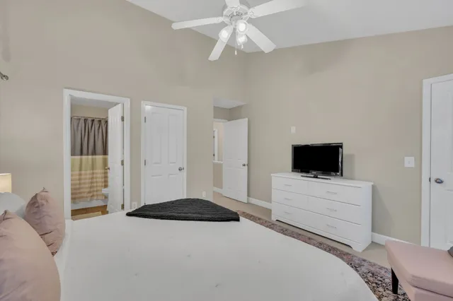 a bedroom with a bed and a flat tv screen on dresser