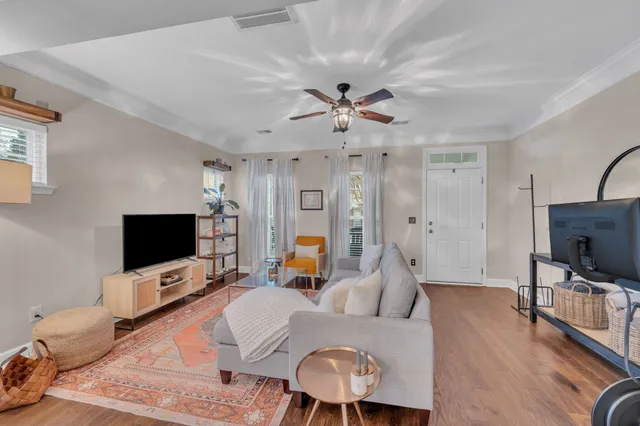 a living room with furniture a flat screen tv and a chandelier
