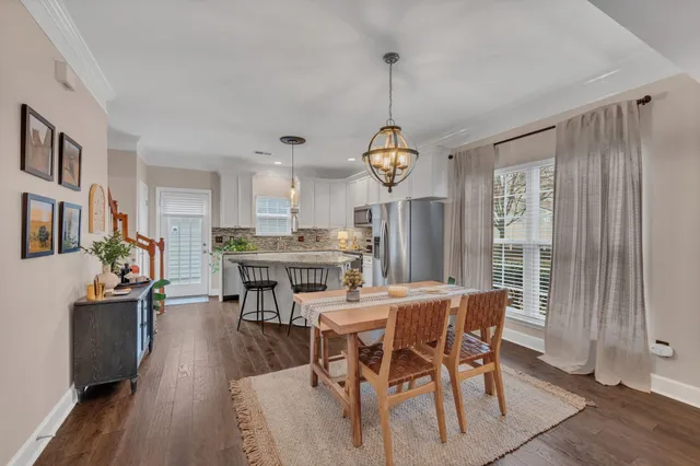 a view of a dining room and livingroom with furniture wooden floor a chandelier