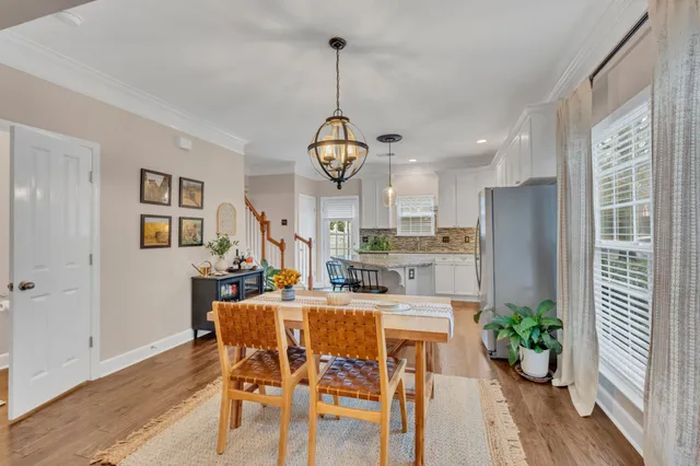 a view of a dining room with furniture a potted plant and wooden floor