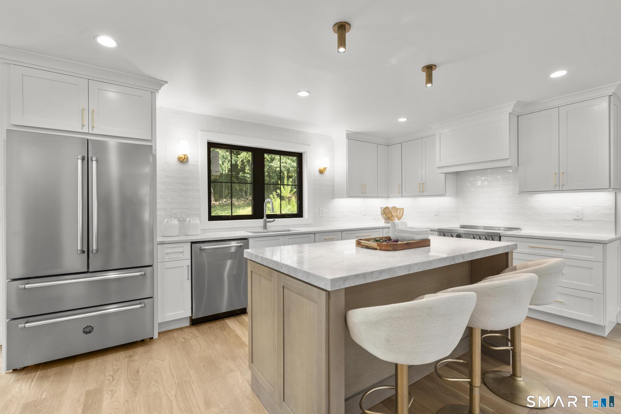 22 Beaver Brook Road Ridgefield, CT 06877 - Photo 6 of 40 a kitchen with stainless steel appliances granite countertop a sink a stove a refrigerator and island with wooden floor
