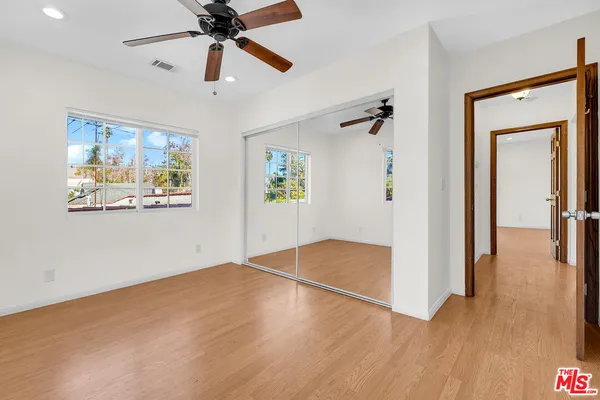 a view of empty room with wooden floor