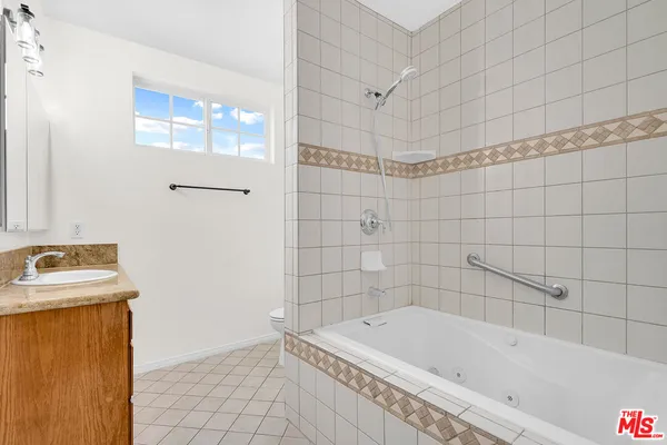 a bathroom with a tub a sink and a shower