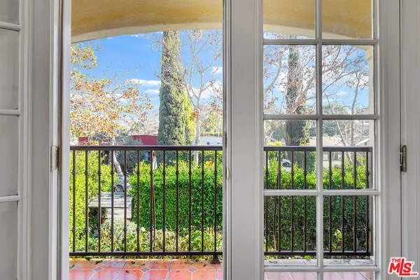 a view of a glass door with a tree in the background