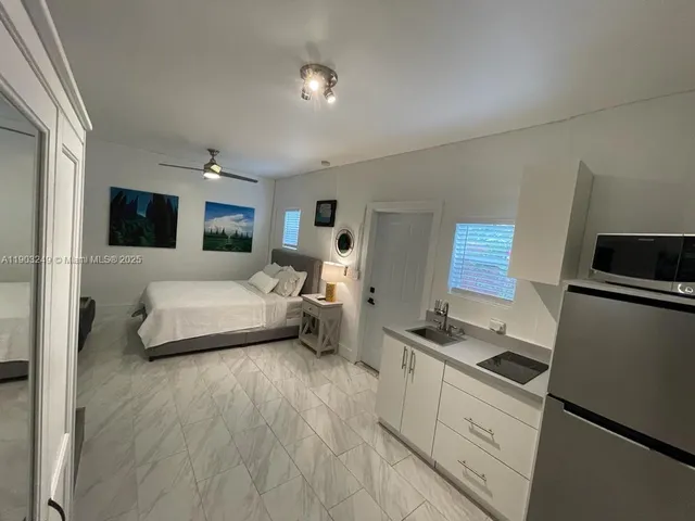 a view of backyard of house with seating space and trees