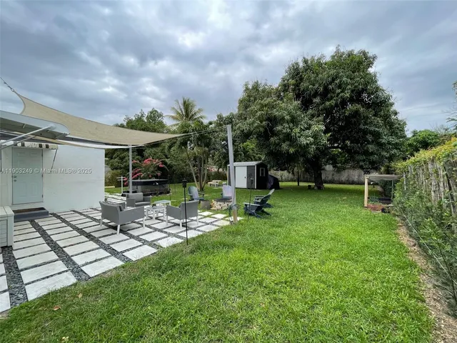 a view of backyard with seating space and trees
