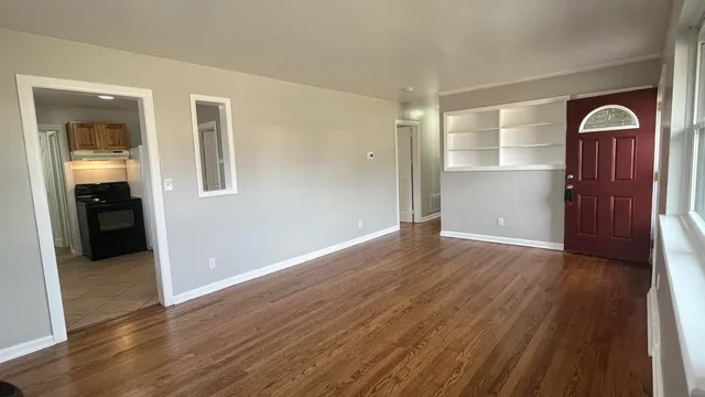 an empty room with wooden floor and closet