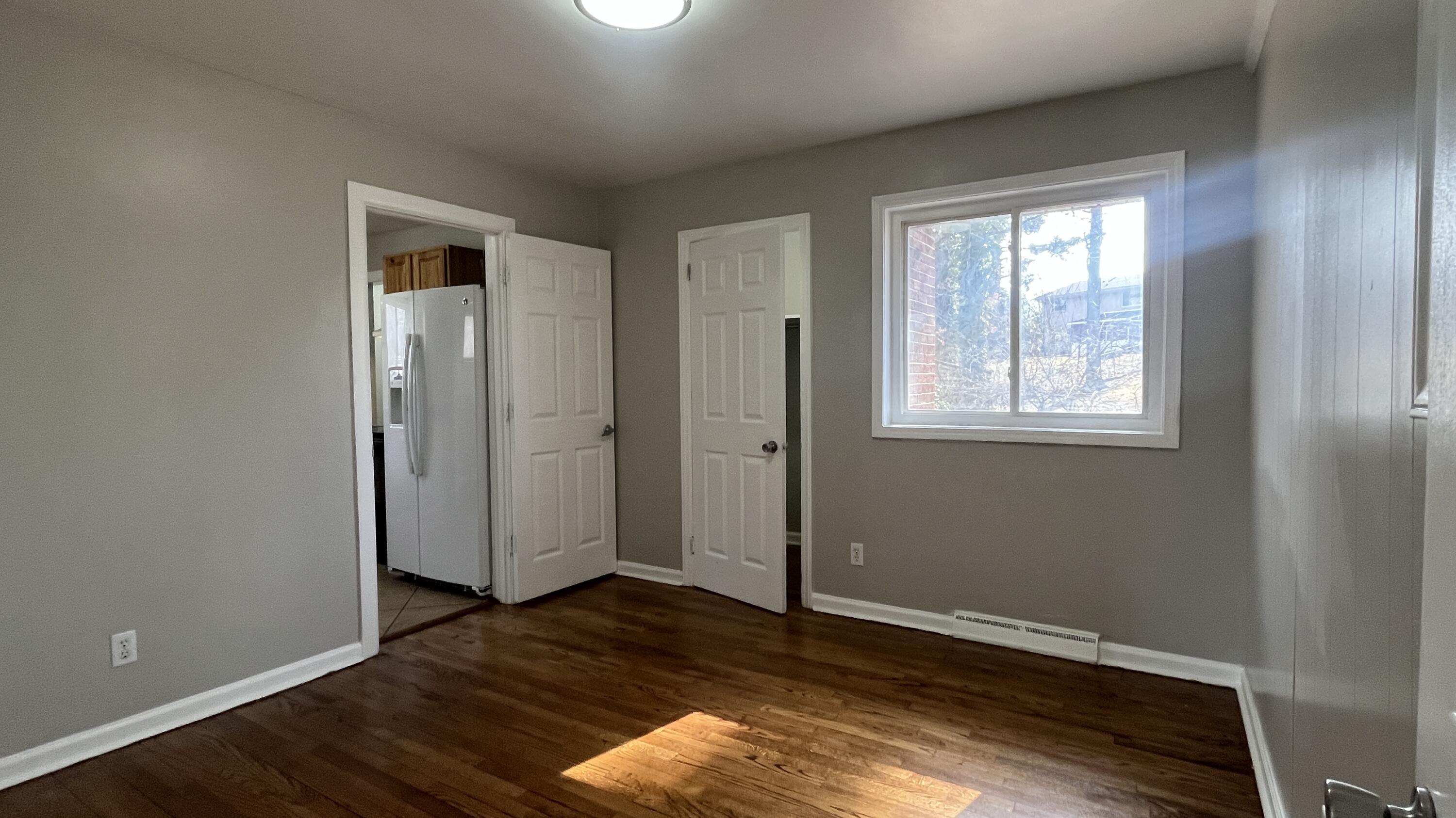 3652 Troutland Avenue Northwest Roanoke, VA 24017 - Photo 6 of 12 an empty room with wooden floor and windows