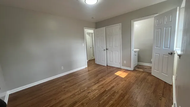 a view of a room with wooden floor and a window