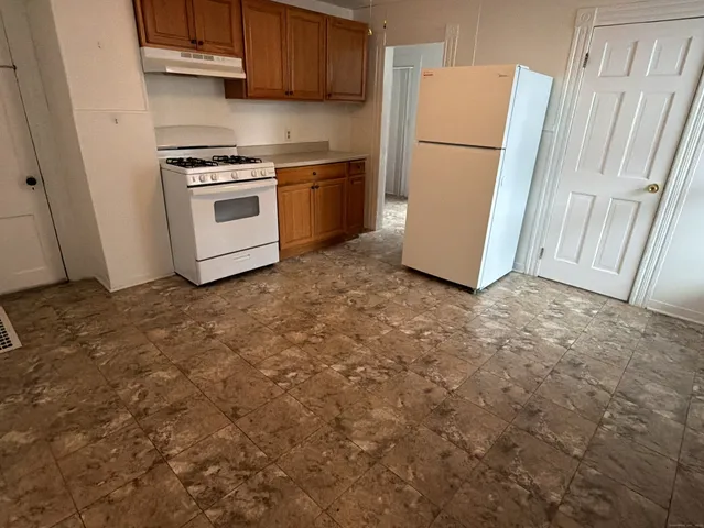 a kitchen with a refrigerator sink stove and cabinets